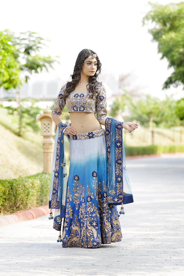 A young woman poses in vibrant traditional Indian clothing in Jaipur, showcasing fashion and cultural heritage.